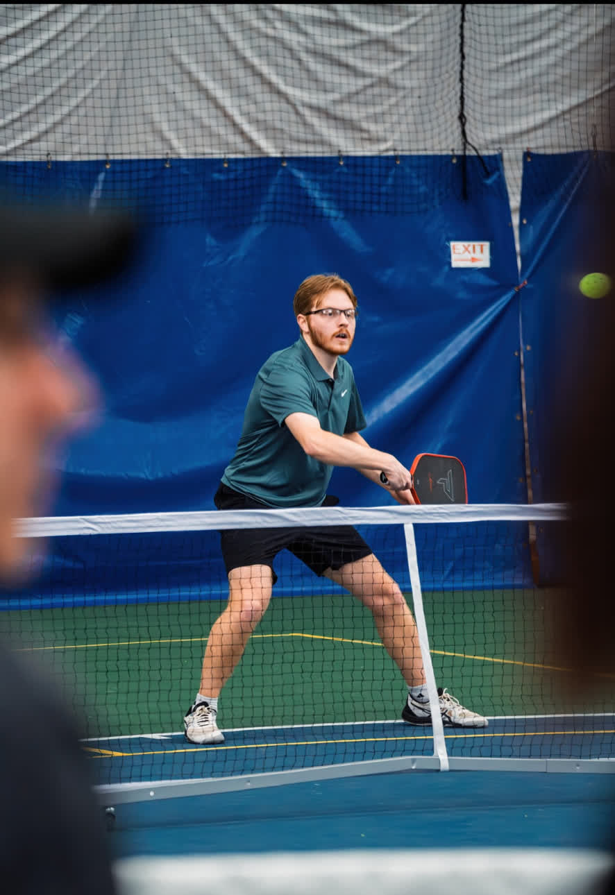 Parker Fisher, head coach, playing pickleball at the net