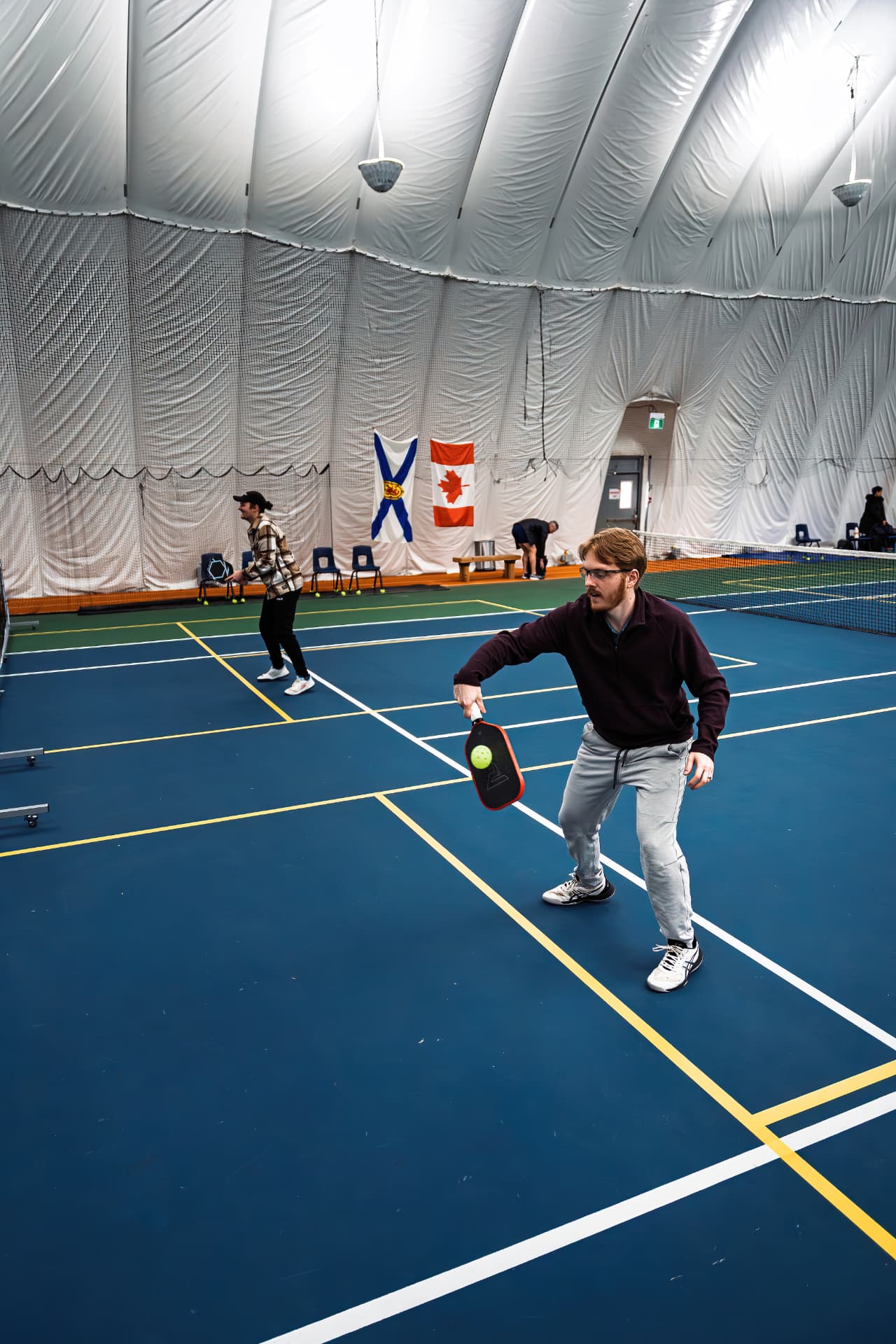 Coach Parker returning a pickleball shot on an indoor court